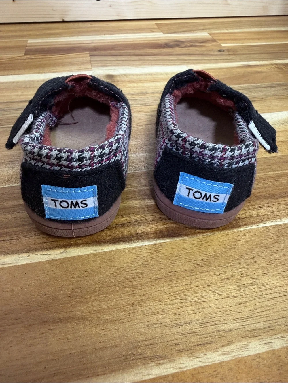 Toms Black Baby Slip-Ons with Rust Accent and Patterned Trim
